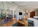 Open concept living room with hardwood floors, a dining table, and a view of the stairs leading to upper level at 12155 W 68Th Pl, Arvada, CO 80004