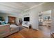 Bright and airy living room with hardwood floors, a large TV, and a glimpse into the updated kitchen at 12155 W 68Th Pl, Arvada, CO 80004