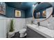 Stylish powder room with dark blue walls, white wainscotting, and modern fixtures at 12155 W 68Th Pl, Arvada, CO 80004