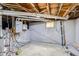 Exposed basement with pipes, water heater, and unfinished walls and ceilings at 2572 Chase St, Edgewater, CO 80214