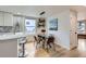 Stylish dining area with glass table, modern lighting, and views from a window at 2572 Chase St, Edgewater, CO 80214