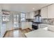 Bright kitchen featuring white cabinets, stainless steel appliances and a stylish backsplash at 2572 Chase St, Edgewater, CO 80214