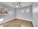 Bright bedroom featuring wood floors, ceiling fan, and two windows for natural light at 5442 S Cedar St, Littleton, CO 80120