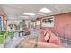 Cozy sunroom with brick accent wall, comfortable seating, tile floors, and multiple windows offering natural light at 5442 S Cedar St, Littleton, CO 80120