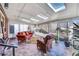 Bright sunroom featuring skylights, large windows, tile flooring, comfortable seating, and ample space for plants at 5442 S Cedar St, Littleton, CO 80120