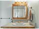 Bathroom vanity with a wood frame mirror, countertop, and a towel rack at 540 S Forest St # 5-204, Denver, CO 80246