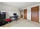 A carpeted bedroom with a desk and chair, showing the closet and bathroom entryways at 540 S Forest St # 5-204, Denver, CO 80246