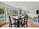 Bright dining area with a dark wood table, seating for four, and natural light from three large windows at 540 S Forest St # 5-204, Denver, CO 80246