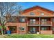 Two-story brown wood apartment complex with balconies and green lawn at 540 S Forest St # 5-204, Denver, CO 80246