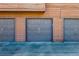 Row of gray garages with brown wood siding and dark asphalt in front at 540 S Forest St # 5-204, Denver, CO 80246