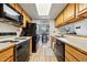 Charming kitchen offers light wood cabinetry, a black refrigerator and stove, and seamless access to the dining area at 540 S Forest St # 5-204, Denver, CO 80246