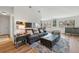 Comfortable living room with hardwood floors, a gray sofa, and a view into the kitchen and dining area at 540 S Forest St # 5-204, Denver, CO 80246
