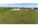 Aerial view of green grassy field with outbuildings in the distance at 41020 Us Highway 36, Bennett, CO 80102