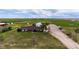 Aerial view of a well-maintained, single-story home with a sprawling green lawn and various outbuildings on a spacious lot at 41020 Us Highway 36, Bennett, CO 80102