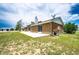 Back exterior view of home, showing brick exterior, patio, and large yard at 41020 Us Highway 36, Bennett, CO 80102