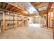 Unfinished basement with exposed ceiling, concrete floor, wood framing, and built-in shelving at 41020 Us Highway 36, Bennett, CO 80102