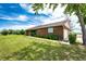 Charming brick home featuring lush front yard, manicured bushes and a well-maintained lawn at 41020 Us Highway 36, Bennett, CO 80102