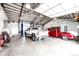 Spacious garage featuring an automobile lift, two trucks, and ample workspace at 41020 Us Highway 36, Bennett, CO 80102