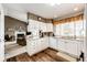 Well-lit kitchen features white cabinetry, stainless steel appliances, and a seamless flow to the dining and living areas at 41020 Us Highway 36, Bennett, CO 80102