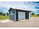 Exterior view of a small outbuilding featuring a roll-up door on a gravel lot at 41020 Us Highway 36, Bennett, CO 80102