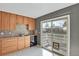 Bright kitchen features wood cabinets, tile backsplash, and sliding door access to a deck at 4531 S Iris St, Littleton, CO 80123