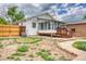Backyard view of home with sunroom, wooden deck, fenced yard and pathway at 10420 Marion St, Northglenn, CO 80233
