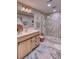 Bathroom featuring a walk-in shower with marble tiling, rain shower head and a wood-look vanity at 10420 Marion St, Northglenn, CO 80233