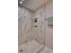 Walk-in shower featuring marble tiling with gold trim and accents and built-in shower caddy at 10420 Marion St, Northglenn, CO 80233