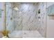 Spacious walk-in shower with marble tiling, a built-in shower caddy, and a gold rain shower head at 10420 Marion St, Northglenn, CO 80233