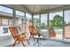 Enclosed sunroom featuring large windows and access to backyard deck at 10420 Marion St, Northglenn, CO 80233