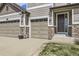 Spacious three-car garage with stone accents and a welcoming front entrance at 3508 Silverado Cir, Frederick, CO 80516