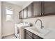 Convenient laundry room with modern appliances, storage cabinets, and sink at 3508 Silverado Cir, Frederick, CO 80516