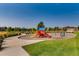 A colorful playground with swings and a slide offers an area for to play and socialize within the neighborhood at 3508 Silverado Cir, Frederick, CO 80516
