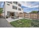 Spacious backyard with a patio, grill, and grassy area bordered by a modern home and wooden fence at 3911 Mariposa St, Denver, CO 80211