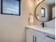 Cozy bathroom features modern fixtures, vanity, round mirror, and a bright window at 3911 Mariposa St, Denver, CO 80211