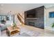 Spacious living room with modern fireplace, hardwood floors, and an open staircase at 3911 Mariposa St, Denver, CO 80211