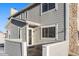 Gray exterior of a two-story townhome with stone accents and a small front patio at 8402 Everett Way # B, Arvada, CO 80005