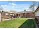 Expansive backyard with lush green lawn, patio area, and charming brick exterior of the home at 10769 Murray Dr, Northglenn, CO 80233