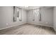 Bedroom featuring wood-look flooring, two windows, and neutral paint at 10769 Murray Dr, Northglenn, CO 80233