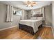 Comfortable bedroom featuring hardwood floors, a cozy bed, and natural light from two windows at 10769 Murray Dr, Northglenn, CO 80233