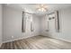 This bedroom has a ceiling fan, two windows and wood-look flooring at 10769 Murray Dr, Northglenn, CO 80233