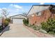 Long driveway leads to detached garage showcasing brick and siding exterior at 10769 Murray Dr, Northglenn, CO 80233