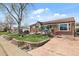 Brick home with an inviting lawn, retaining wall, and driveway leading to the property at 10769 Murray Dr, Northglenn, CO 80233