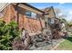 Charming front exterior detail featuring mature foliage, decorative wagon wheels and a brick facade at 10769 Murray Dr, Northglenn, CO 80233