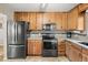 Well-lit kitchen featuring wood cabinets, granite countertops, and updated appliances at 10769 Murray Dr, Northglenn, CO 80233