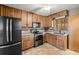 Well-equipped kitchen featuring stainless steel appliances, wooden cabinetry, and tile flooring at 10769 Murray Dr, Northglenn, CO 80233
