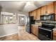 Well-equipped kitchen featuring stainless steel appliances, wooden cabinetry, and tile flooring at 10769 Murray Dr, Northglenn, CO 80233