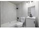 Bathroom featuring a shower-tub combo with white tiled walls, a toilet, and a vanity sink at 3430 N Clayton St, Denver, CO 80205
