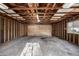 Unfinished garage with exposed wood framing, concrete floor, and a door leading outside at 3430 N Clayton St, Denver, CO 80205