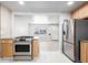 The open kitchen features stainless steel appliances and granite countertops at 3430 N Clayton St, Denver, CO 80205